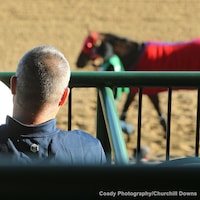 A racing fan peruses the track program at Churchill Downs